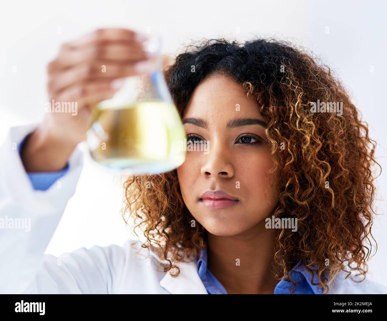 Nach einer Lösung suchen. Ausgeschnittene Aufnahme einer jungen Wissenschaftlerin, die im Labor ein Experiment durchführt. Stockfoto