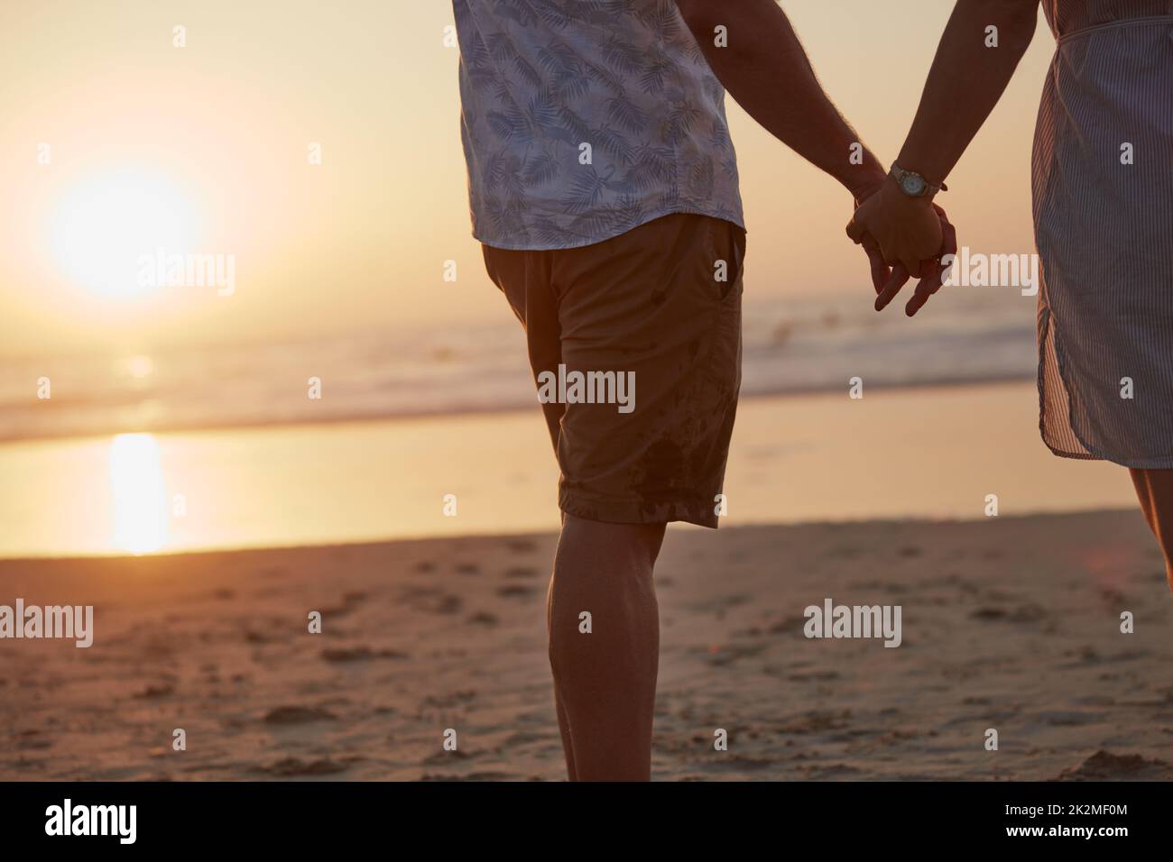 Ihre Hand gehört zu meiner. Rückansicht eines reiferen Paares, das eine gute Zeit am Strand verbringt. Stockfoto