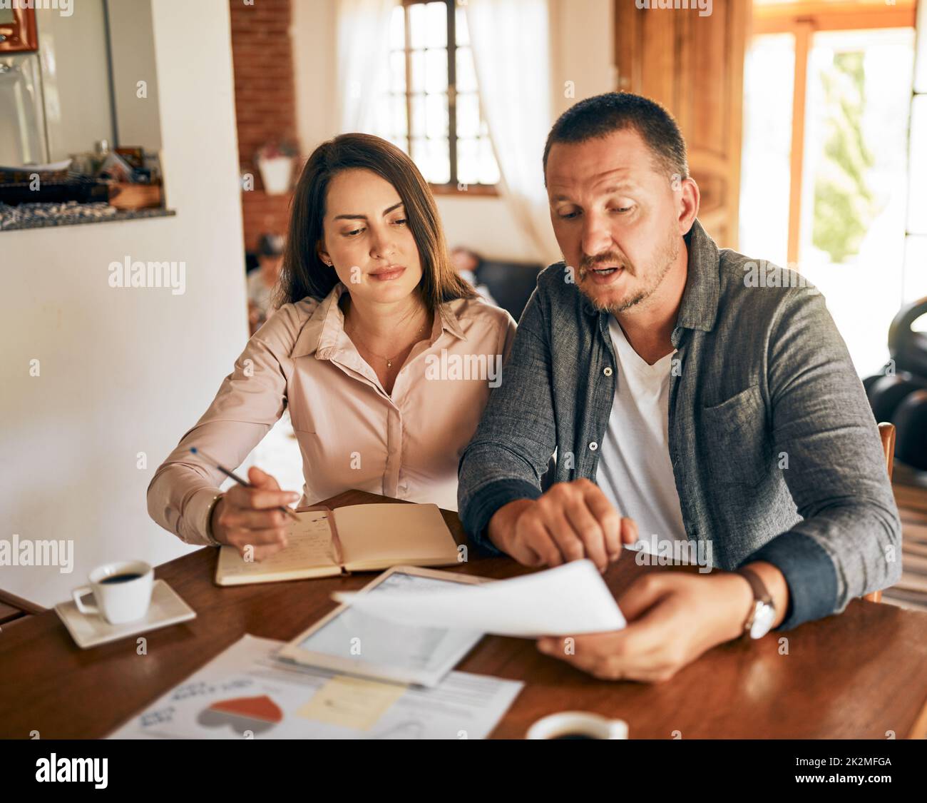 Familienplanung gemeinsam. Eine kurze Aufnahme eines Ehepaares, das zu Hause sein Budget plant. Stockfoto