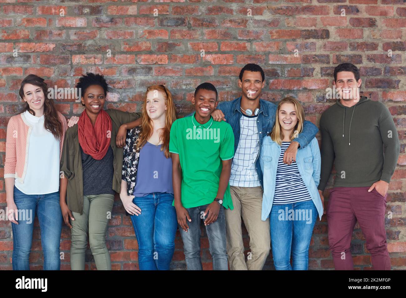 Alle lächeln auf dem Campus. Porträt einer Gruppe von Studenten, die in ihrem Universitätsgebäude stehen. Stockfoto