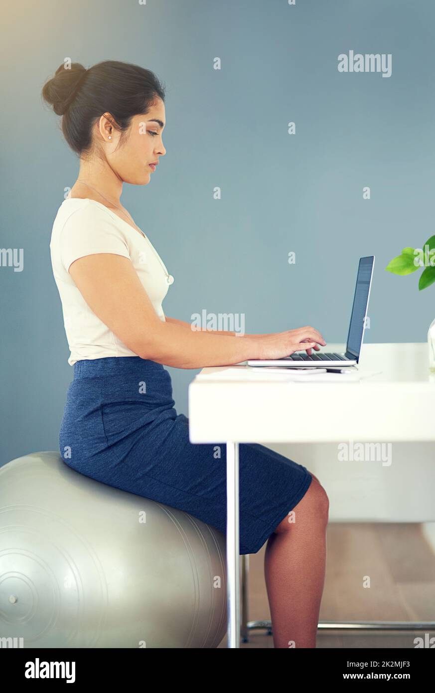 Balance zwischen Arbeit und Bewegung. Eine kurze Aufnahme einer jungen Geschäftsfrau, die zu Hause an ihrem Laptop arbeitet. Stockfoto