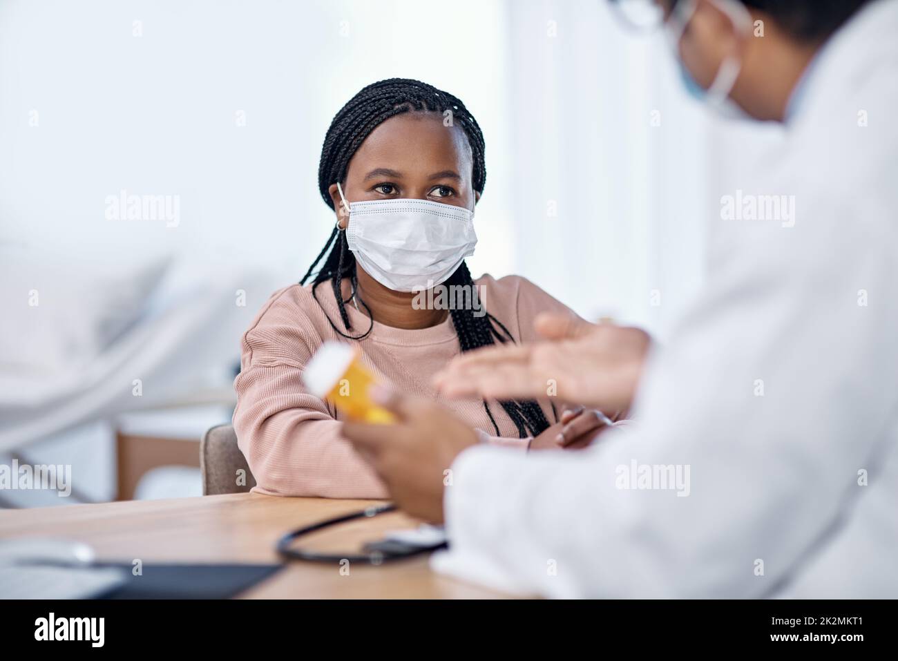 Den Anweisungen des Arztes zuhören. Aufnahme einer jungen Frau, die während einer Konsultation Medikamente von einem Arzt erhält. Stockfoto