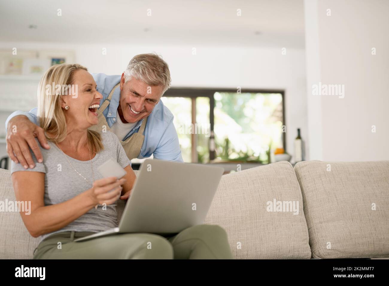 Lachen ist unser Geheimnis für eine ewige Liebe. Aufnahme eines reifen Paares, das über etwas lachte, das sie auf dem Laptop sahen. Stockfoto