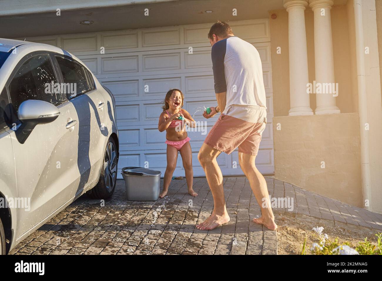 Foto zum Thema Ein kleines Mädchen, das ein Auto mit einem Schlauch wäscht  – Bild zu Hochdruckreinigung auf Unsplash
