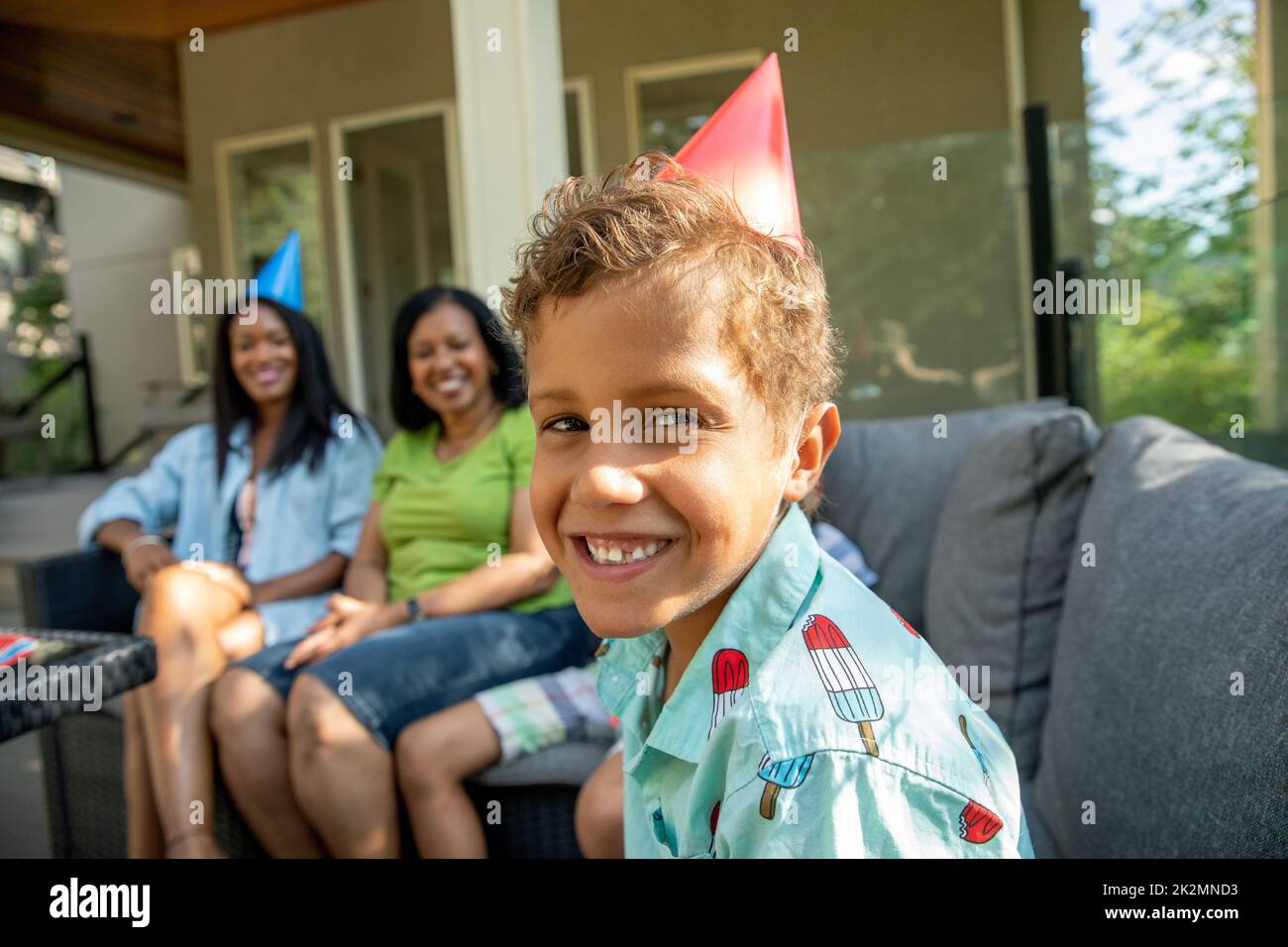 Porträt eines Jungen mit Kegelhut lächelnd auf der Geburtstagsfeier Stockfoto