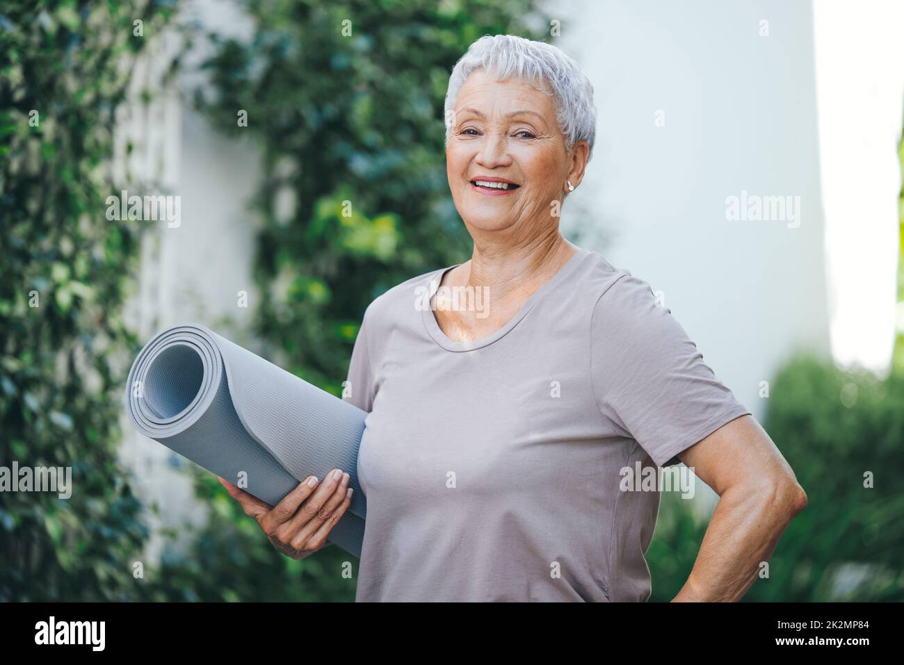 Fitness ist ein Lebensstil. Porträt einer älteren Frau, die vor ihrem Training im Freien eine Trainingsmatte in der Hand hält. Stockfoto