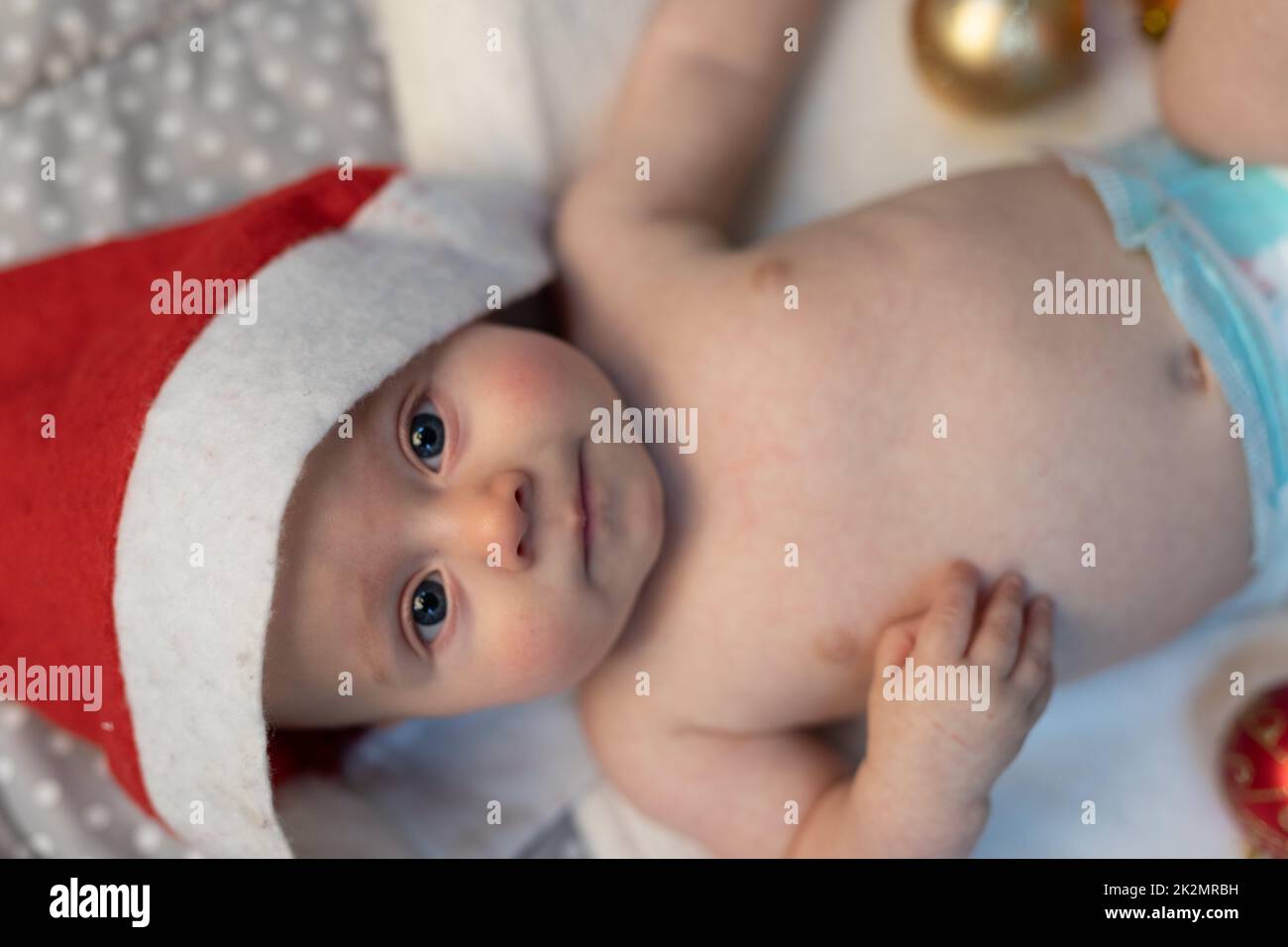 Ein kleines Neugeborenes, das einen Weihnachtsmann-Hut trägt Stockfoto
