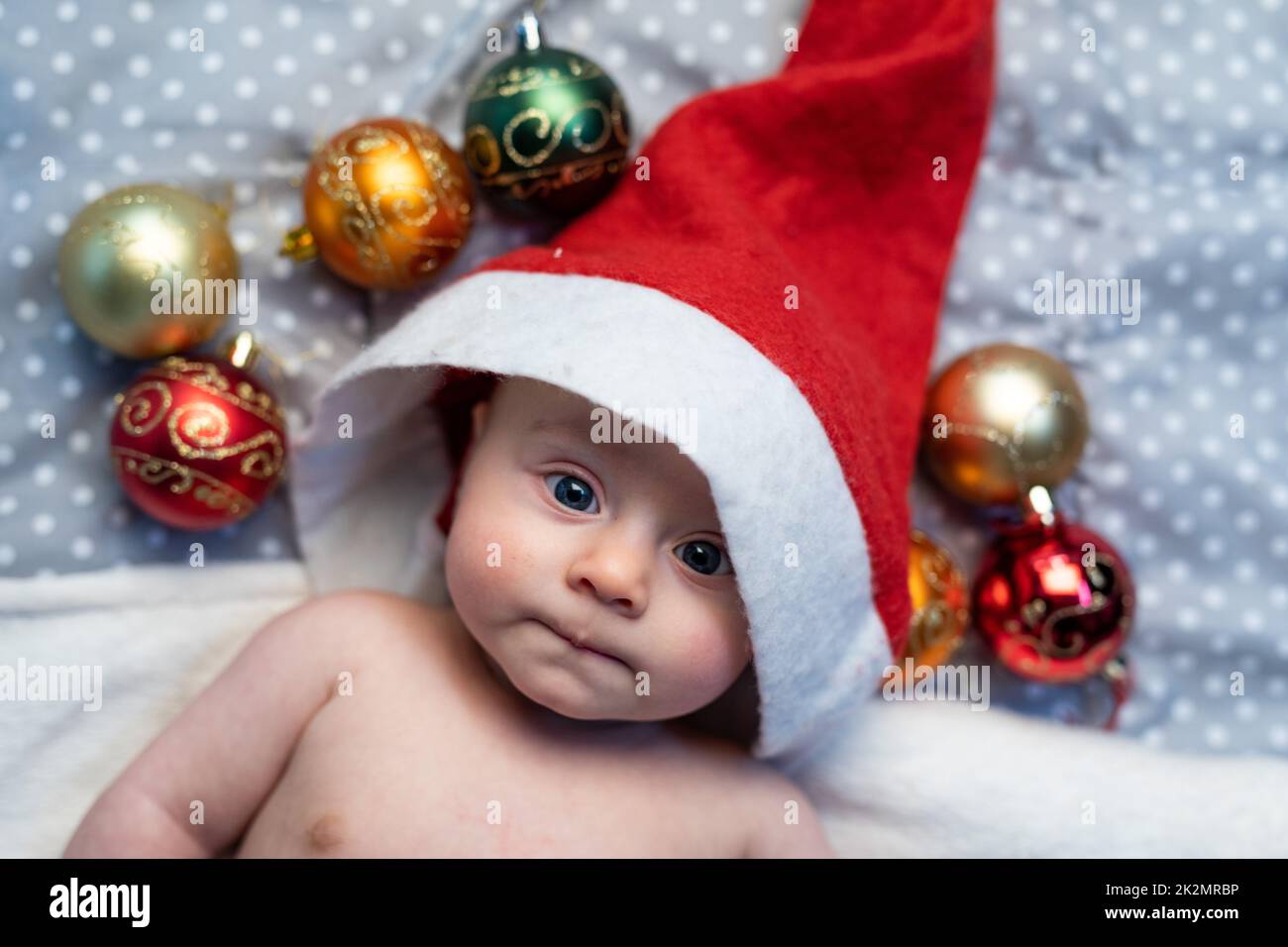 Süßes kleines Baby mit rotem Weihnachtsmann-Hut Stockfoto