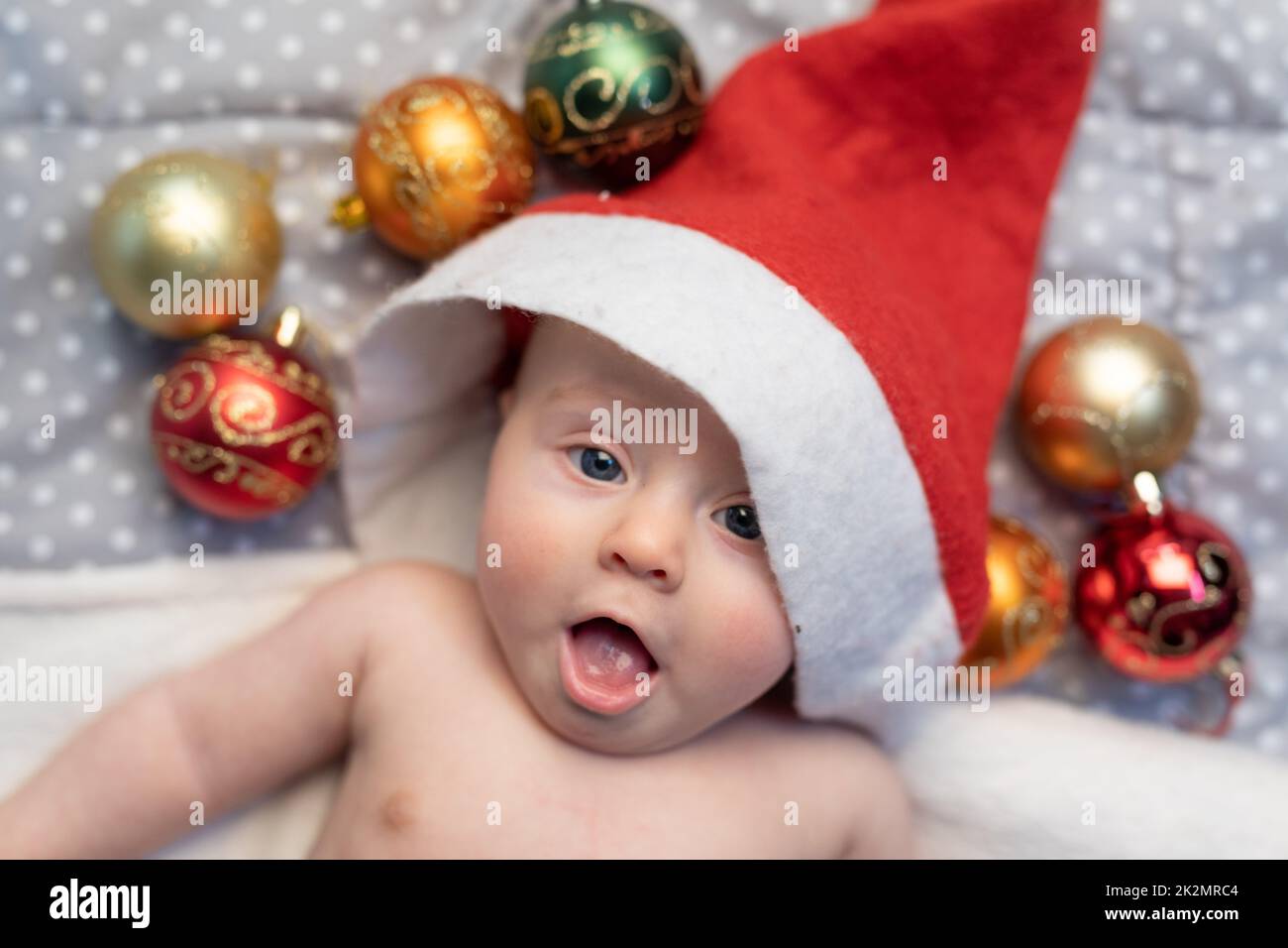 Weihnachtsbaby mit rotem Weihnachtsmannmütze Stockfoto