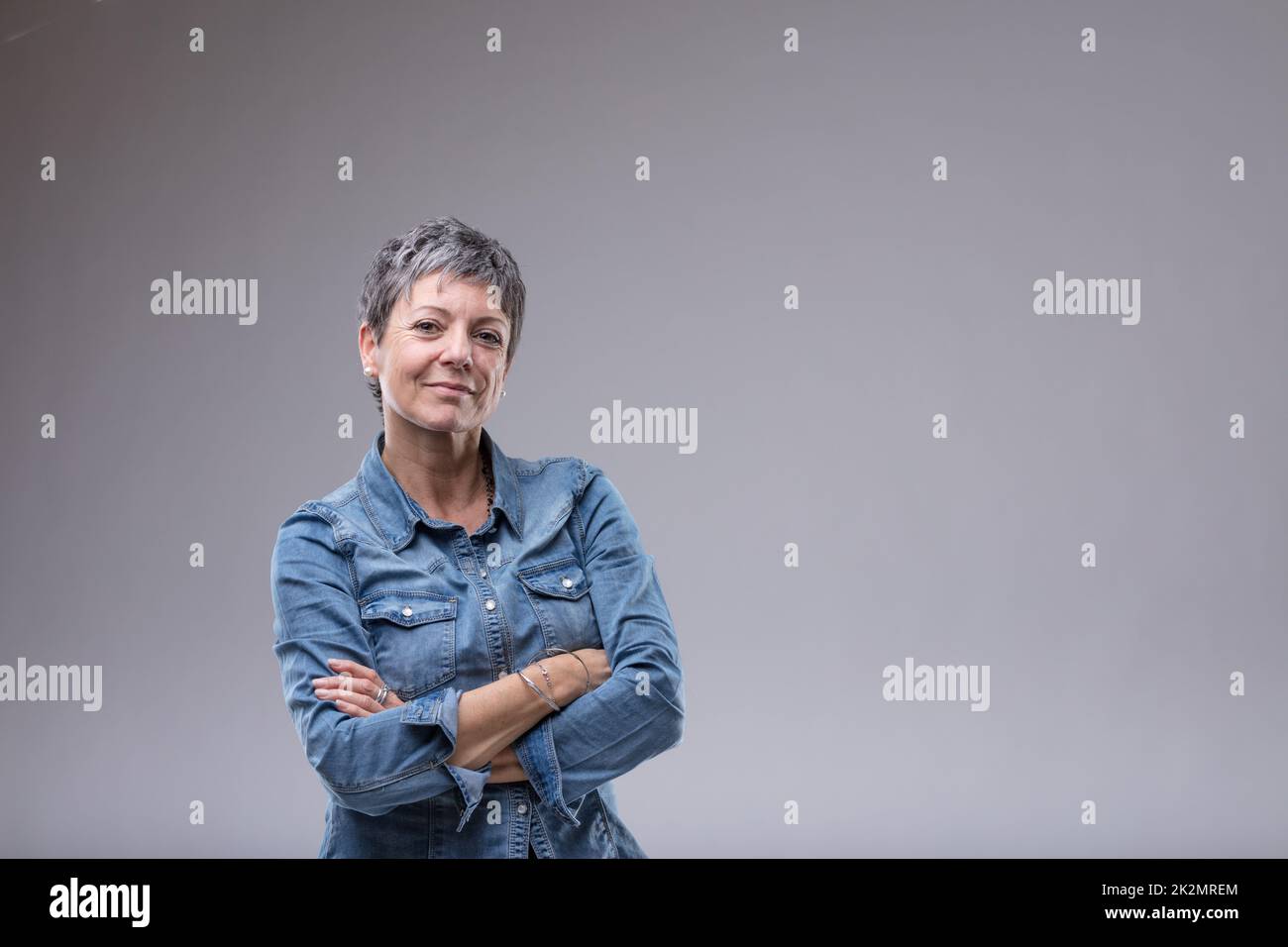 Selbstbewusste Seniorin mit gefalteten Armen Stockfoto