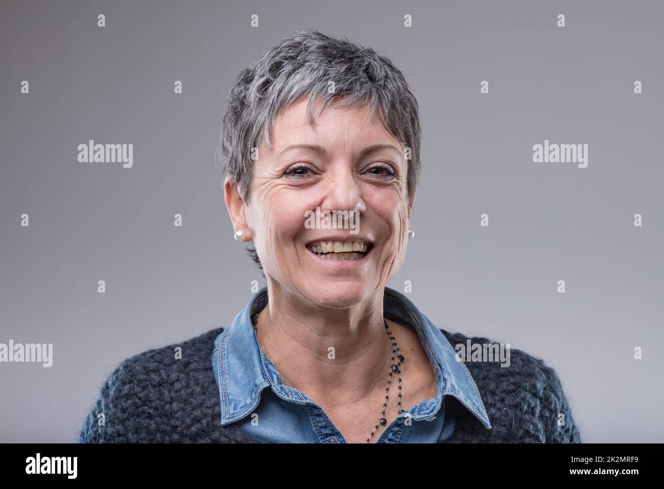 Lächelnde, glückliche, ältere Frau mit kurzen Haaren Stockfoto