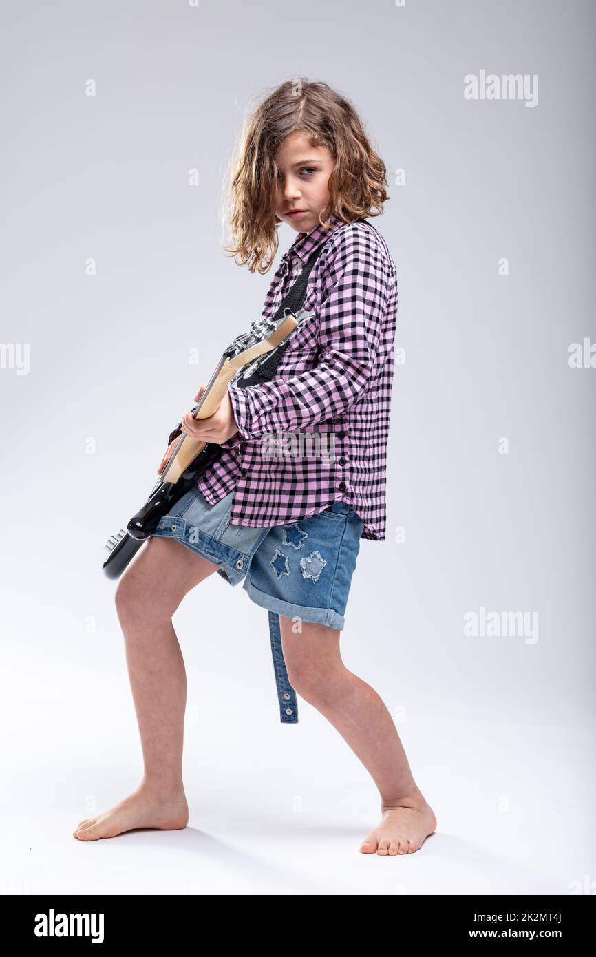 Begabtes junges Schulmädchen, das elektrische Gitarre spielt Stockfoto