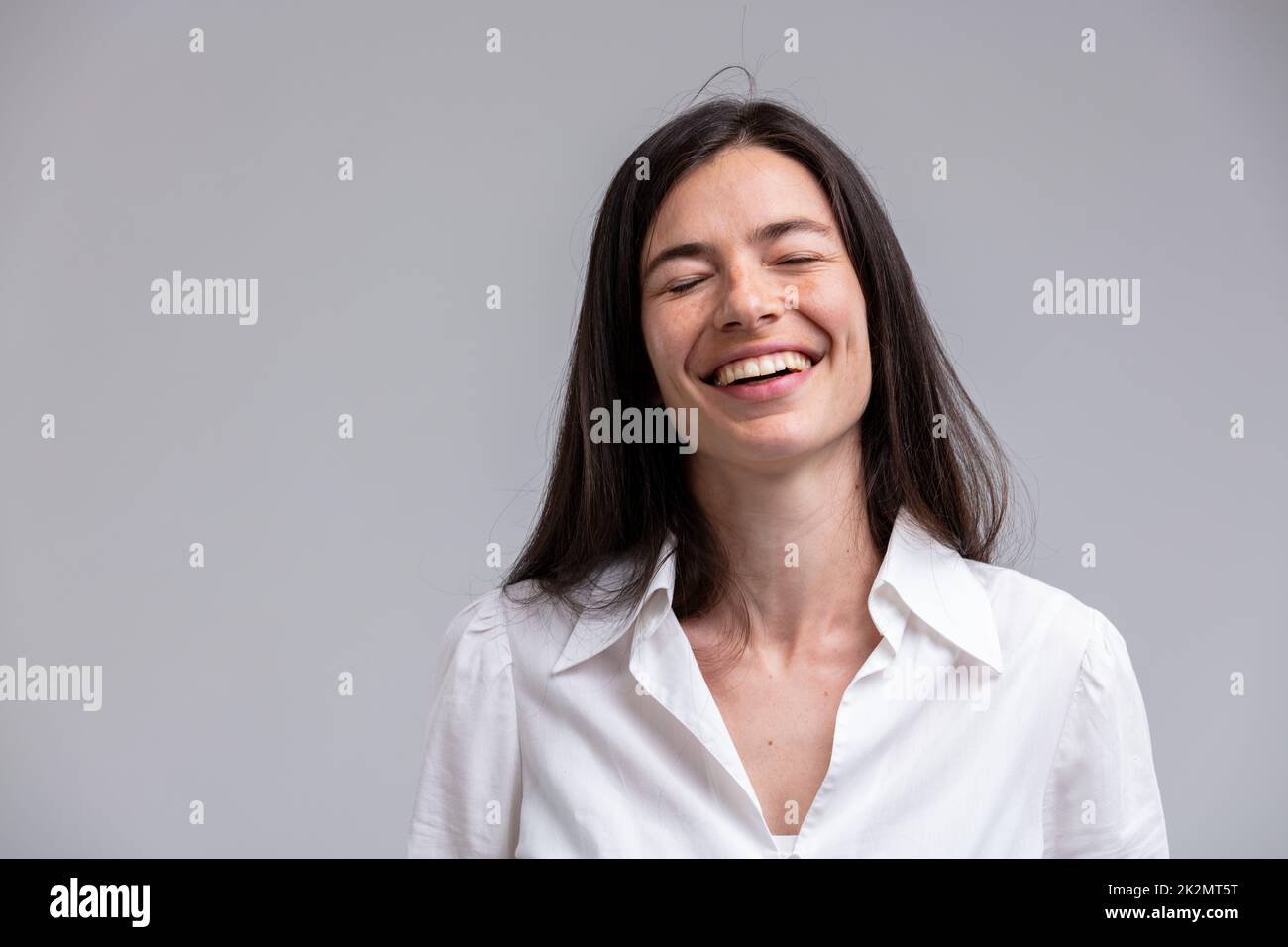 Porträt einer jungen, langhaarigen, lachenden Frau Stockfoto