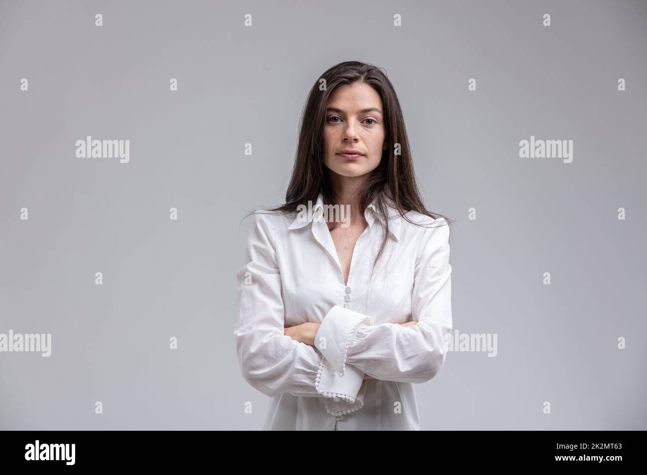 Langhaarige Frau mit gekreuzten Armen Stockfoto