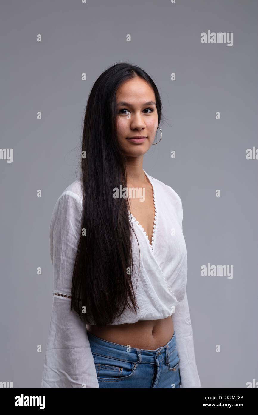 Attraktive, schlanke junge Frau mit langen, glatten, dunklen Haaren Stockfoto