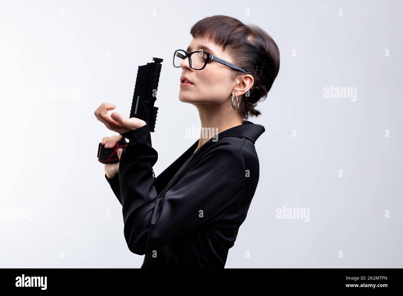 Attraktive Frau mit Handfeuerwaffe und Kopierraum Stockfoto