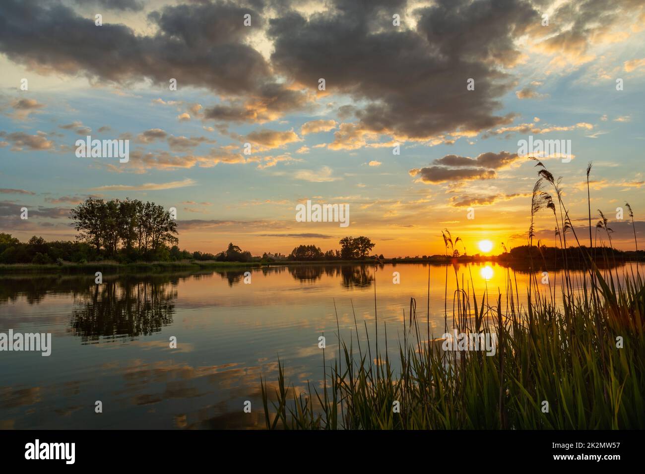 Wunderschöner Sonnenuntergang über einem ruhigen See, Sommertag Stockfoto