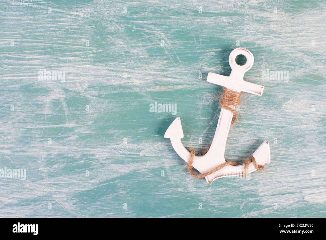 Weißer Anker auf blauem texturierten Hintergrund, maritimes Leben, Segeltörn, Sommerurlaub, Tourismuskonzept, Hafen Stockfoto
