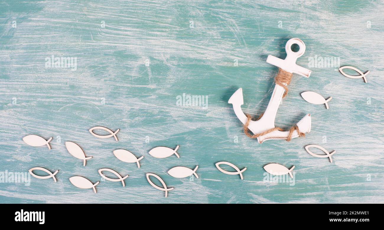 Weißer Anker und Fisch auf blauem Hintergrund, maritimes Leben, Segeltörn, Sommerurlaub, Tourismuskonzept, Hafen Stockfoto