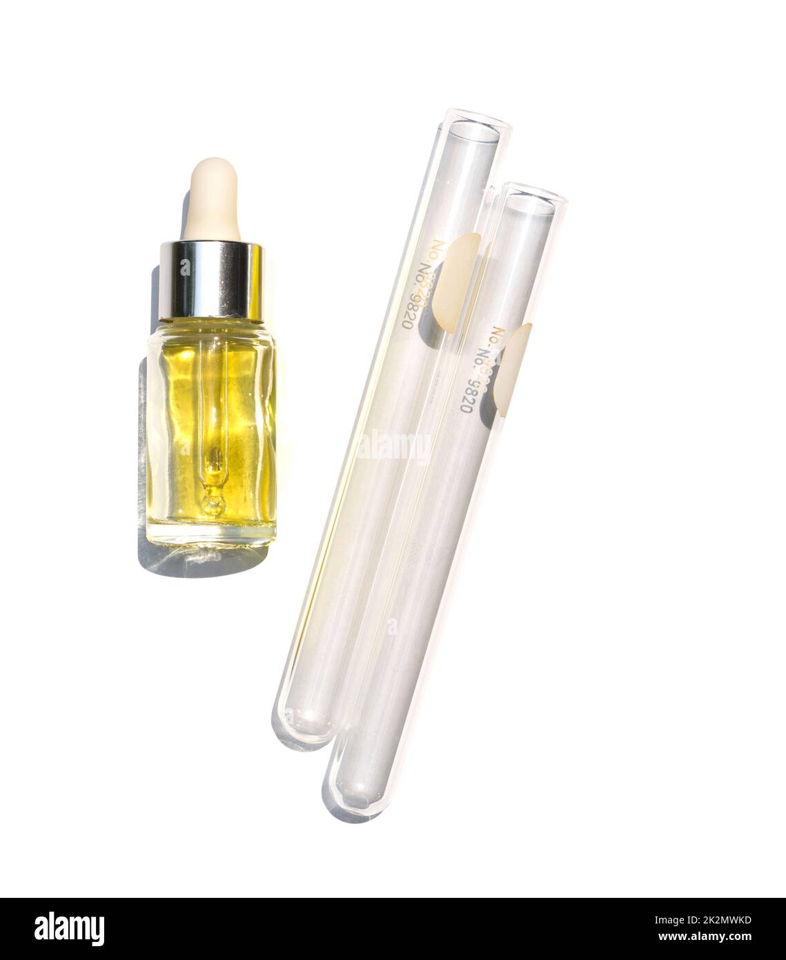 Gelbe kosmetische Flüssigkeit (Öl) in der Tropfflasche neben dem Reagenzglas platzieren. Stockfoto