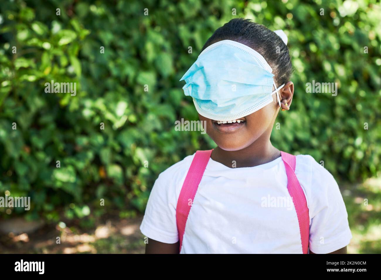 Ist es eine Augenmaske. Aufnahme eines kleinen Mädchens, das in der Natur ihre Augen mit einer Maske bedeckt. Stockfoto