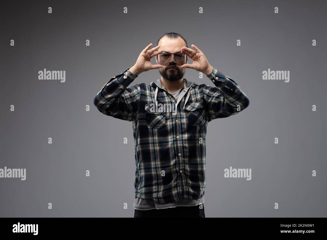 Ein Mann, der ein Stück Glas vor seinen Augen hält Stockfoto