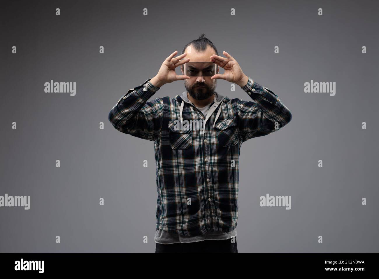 Ein Mann, der durch ein Stück Glas in die Kamera schaut Stockfoto