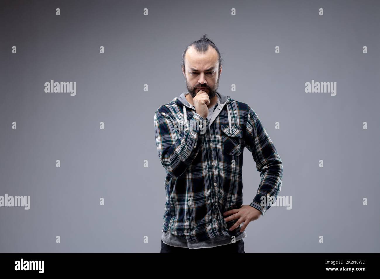 Rücksichtsvoller Mann mit der Hand am Kinn Stockfoto