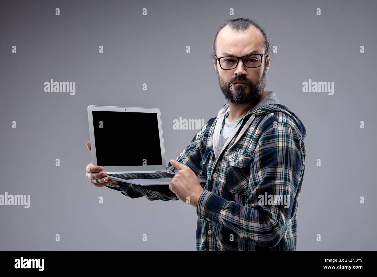 Ein dogmatischer Mann, der auf den Bildschirm eines Laptops zeigt Stockfoto