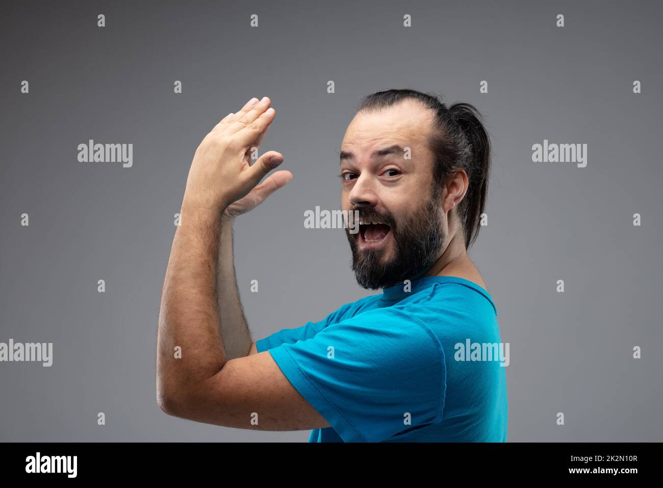 Seitenporträt eines glücklichen bärtigen Mannes, der klatscht Stockfoto