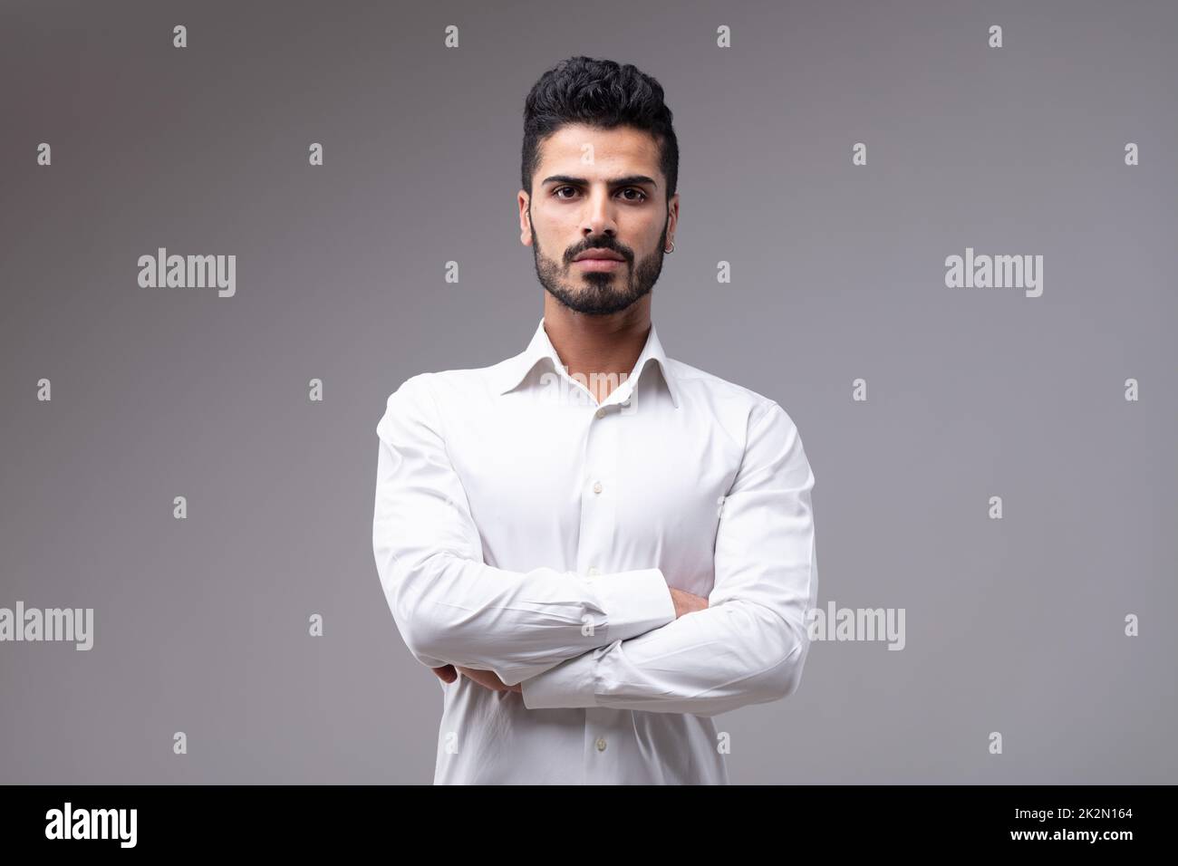 Junger, bärtiger Mann mit verschränkten Armen Stockfoto