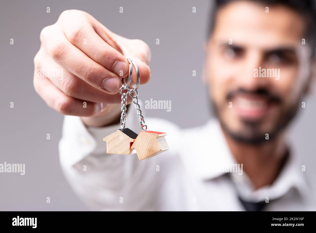 Lächelnder Mann mit Schlüsselringen in Form eines Hauses Stockfoto