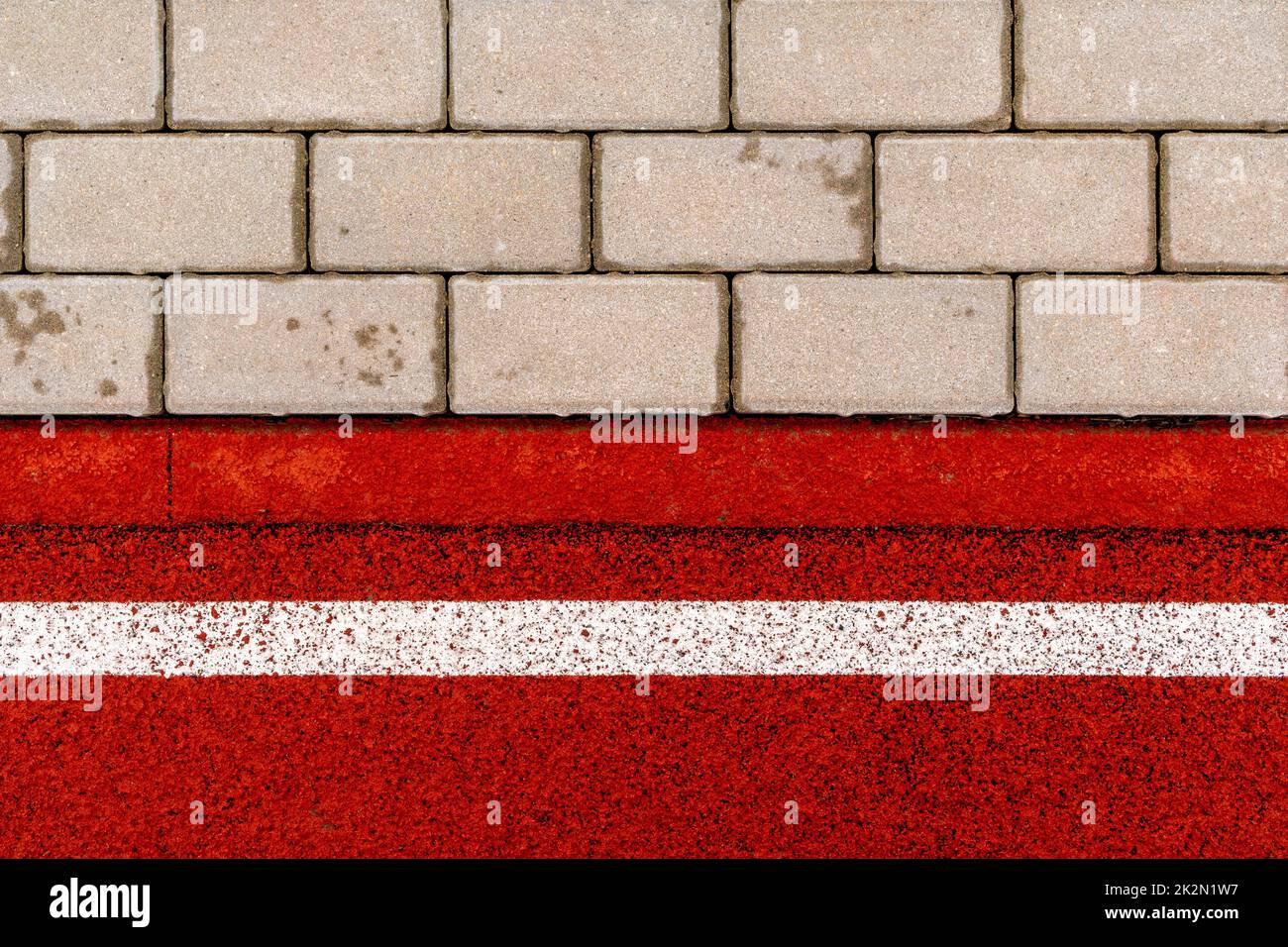 Rote Joggingstrecke aus weichem Gummi und Fliesenbelag Stockfoto