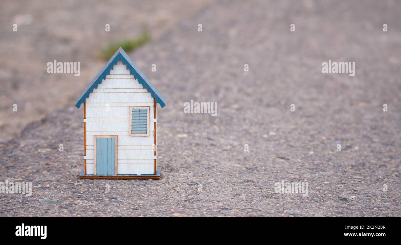 Kleines Haus steht auf einer Straße, Immobilien-Konzept, Vermietung oder Kauf eines Hauses, Reise-und Urlaub Symbol Stockfoto