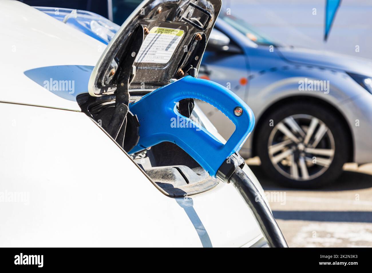 Elektrofahrzeug oder Elektroauto mit eingestecktem Netzkabel Stockfoto