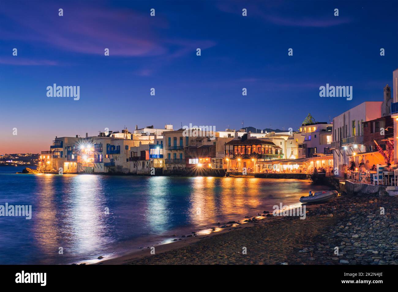 Sonnenuntergang in Mykonos, Griechenland, mit Kreuzfahrtschiff und Yachten im Hafen Stockfoto