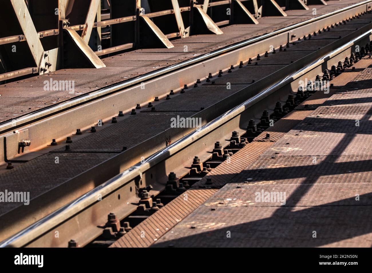 Detail von Bahnstrecken auf alten Metal Bridge, sun Casting Shadows auf Ihnen. Stockfoto