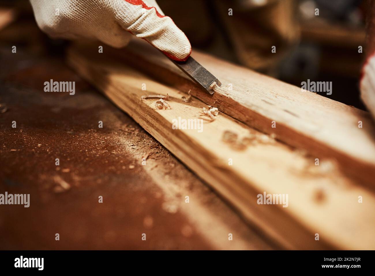 Dieses Tool wirkt Wunder. Nahaufnahme eines unerkennbaren Zimmermanns, der nachts ein Stück Holz in einer Werkstatt ablegt. Stockfoto