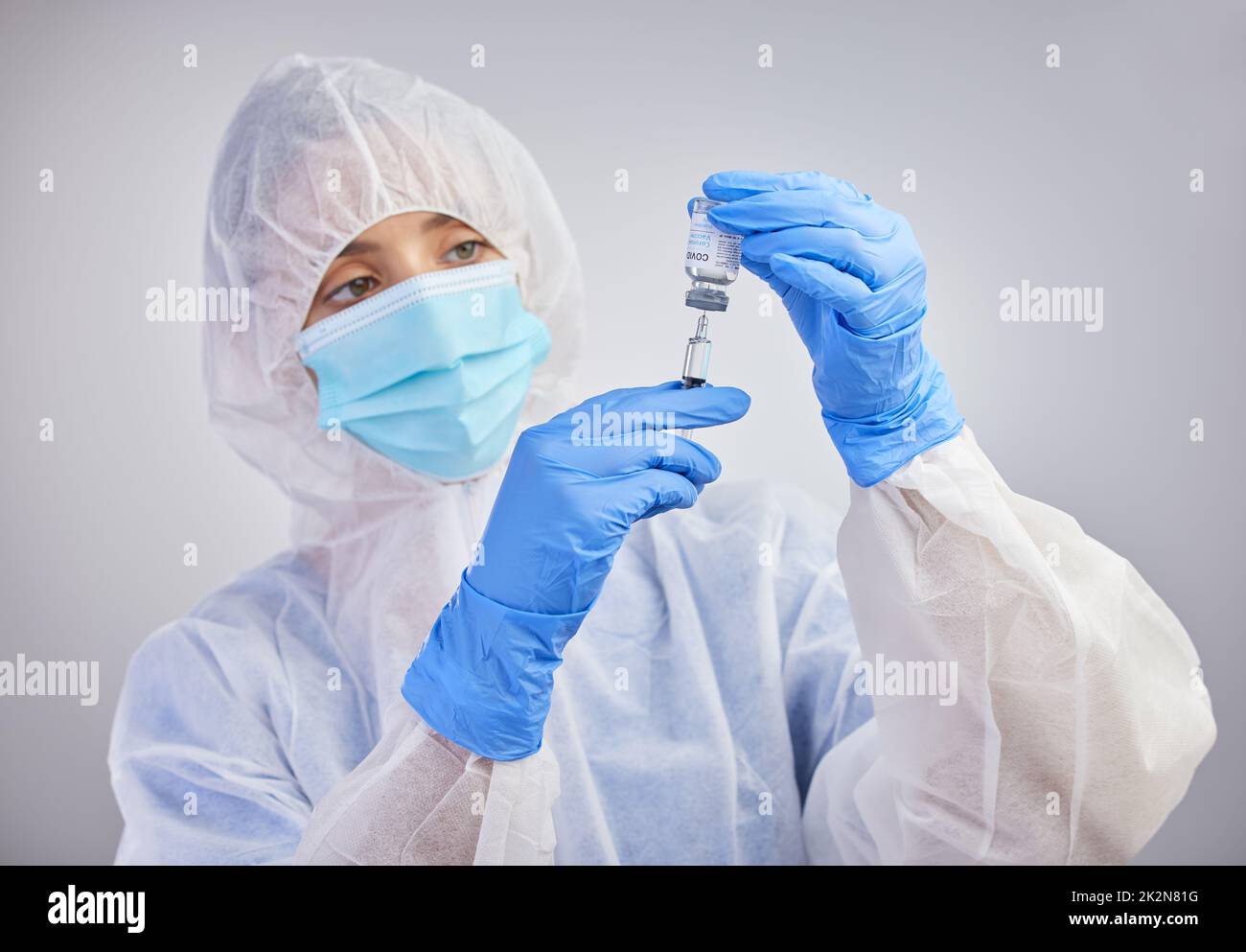 Herdenimmunität ist möglich. Aufnahme einer Krankenschwester, die vor dem Hintergrund eines Studios eine Spritze mit Impfflüssigkeit füllte. Stockfoto