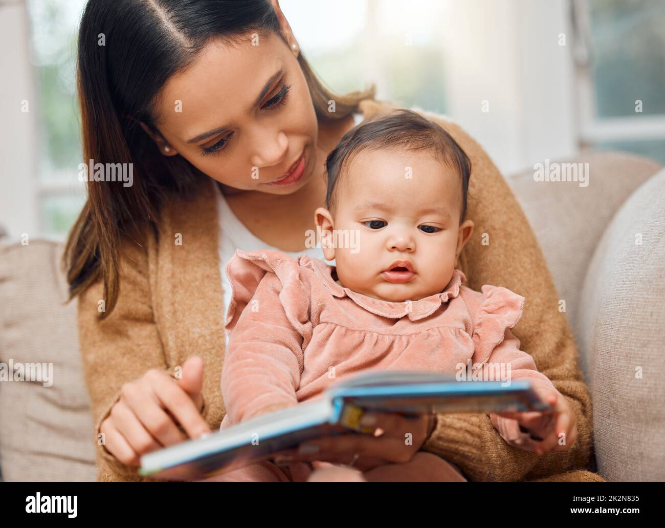 Sie liebt ein gutes Bilderbuch. Aufnahme einer Frau, die ihr kleines Mädchen vorliest. Stockfoto
