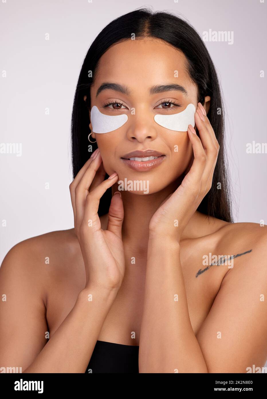 Denn wer will Taschen. Studioporträt einer attraktiven jungen Frau, die unter Augenflecken vor einem rosa Hintergrund trägt. Stockfoto