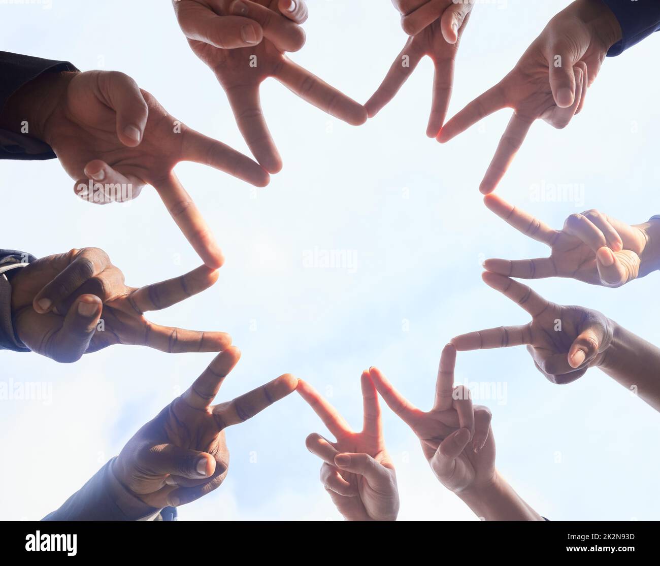 Du bist ein Stern in meinen Augen. Unten sehen Sie eine Gruppe von nicht erkennbaren Geschäftsleuten, die sich vor weißem Hintergrund in die Hände schlossen. Stockfoto