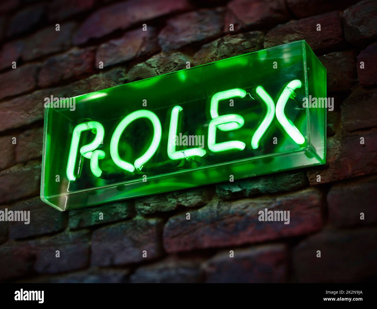 ROLEX-Uhrenschild beleuchtet in Neon. Hersteller von Uhren der Luxusmarke Stockfoto
