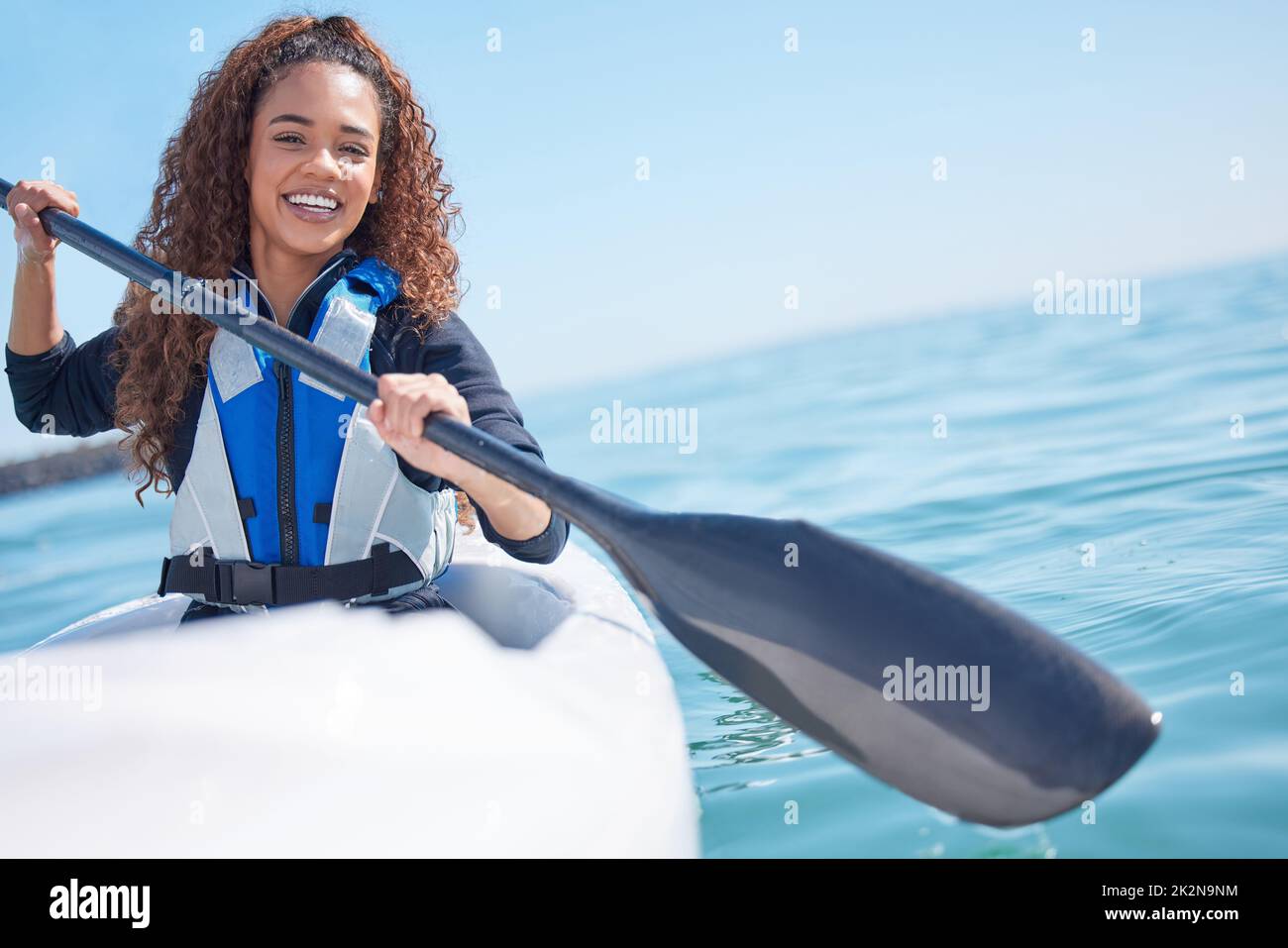 Das Paradies ist nur einen Paddel entfernt. Porträt einer jungen Frau, die an einem See Kajak gefahren ist. Stockfoto