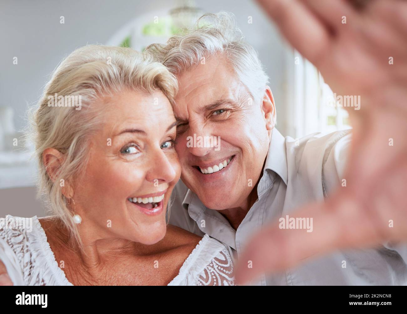 Gesicht Selfie, ältere Paar und Liebe Lächeln im Ruhestand im häuslichen Interieur. Portrait, glückliche ältere und pensionierte romantische Lebenspartner von Mann und Frau Stockfoto