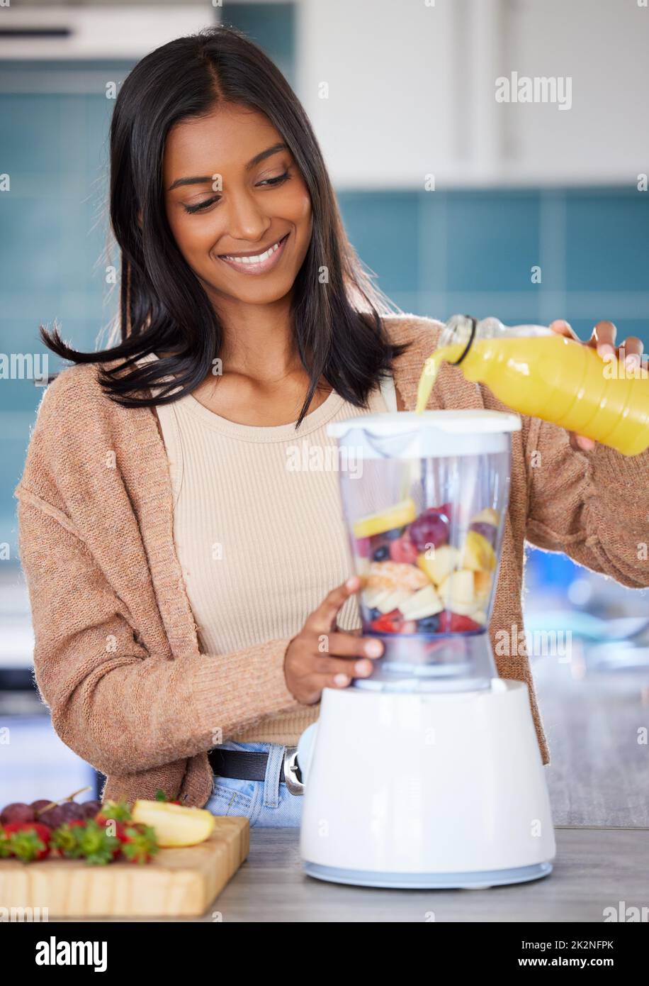 Ein köstliches Getränk in nur wenigen Minuten aufschlagen. Aufnahme einer jungen Frau, die zu Hause einen gesunden Smoothie vorbereitet. Stockfoto