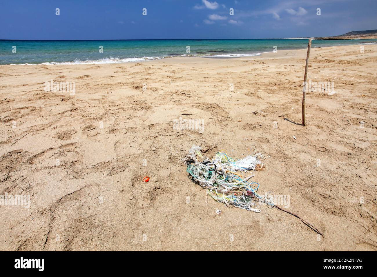 Perfekter leerer, unberührter Strand, kleiner Müllhaufen (verwickelte Plastikseile) auf feinem Sand, ruhiges Meer im Hintergrund. Ozeanabfallkonzept. Karpass, Nordzypern Stockfoto