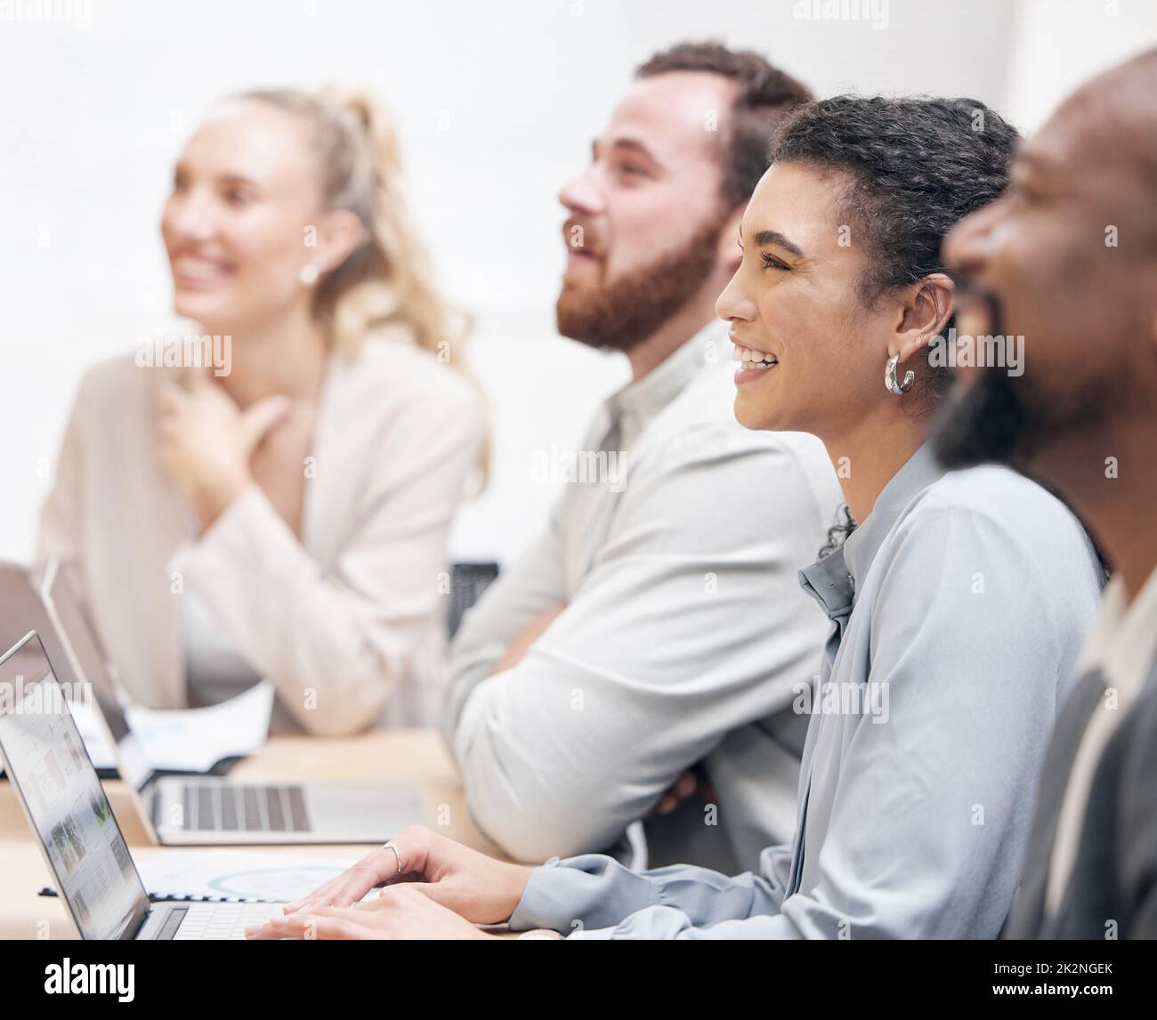 Auffällige Informationen. Eine kleine Aufnahme einer attraktiven jungen Geschäftsfrau und ihrer Kollegen, die während eines Meetings im Sitzungssaal sitzen. Stockfoto