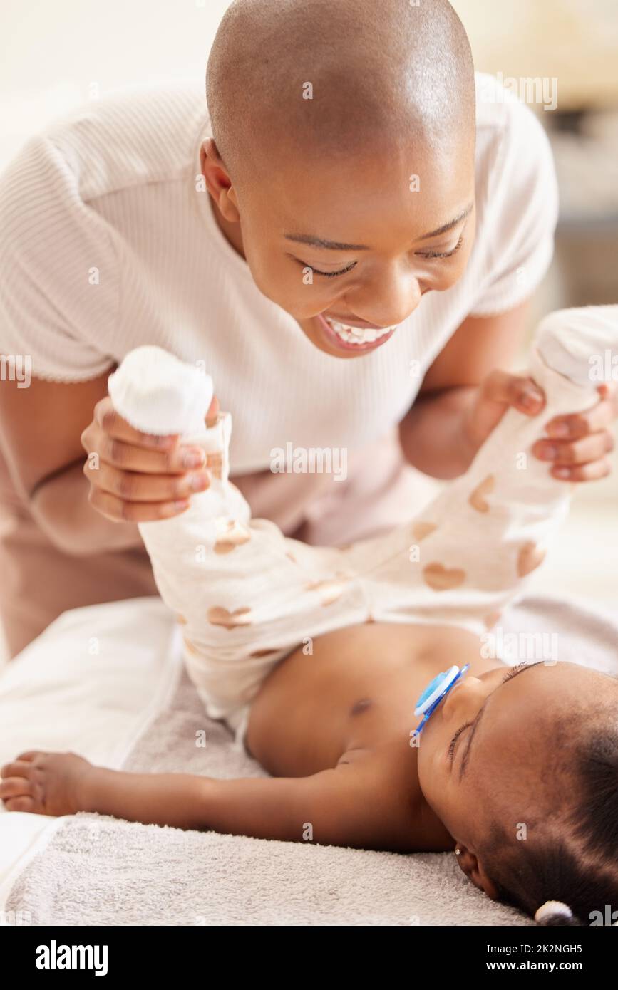 Wir bringen dich in ein anderes niedliches Outfit. Aufnahme einer Mutter, die zu Hause die Kleidung ihrer kleinen Töchter wechselt. Stockfoto