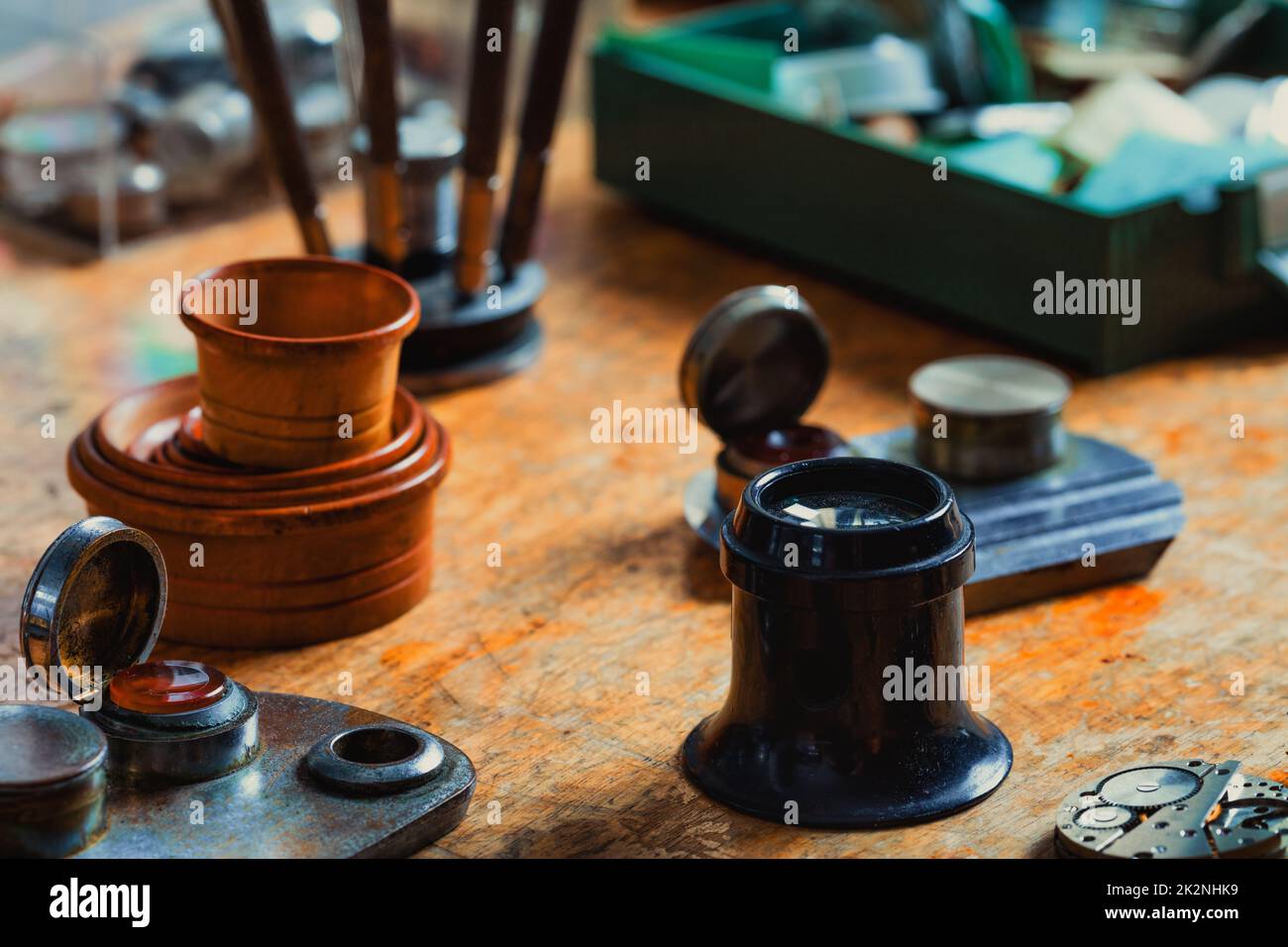 Uhrmacherwerkzeuge und eine Schmucklupe auf einer Werkbank Stockfoto
